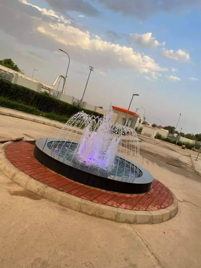 Circular fountain with colour lighting at dusk