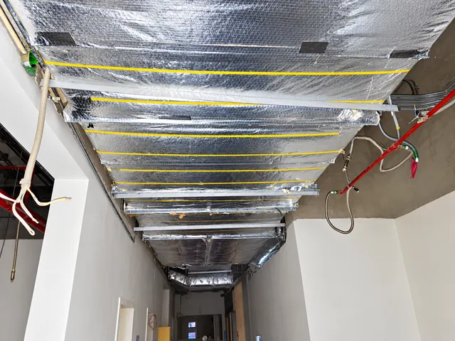 Insulated ductwork installed along a corridor ceiling