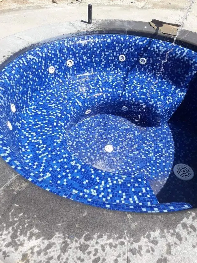 Circular spa with blue mosaic and integrated seating