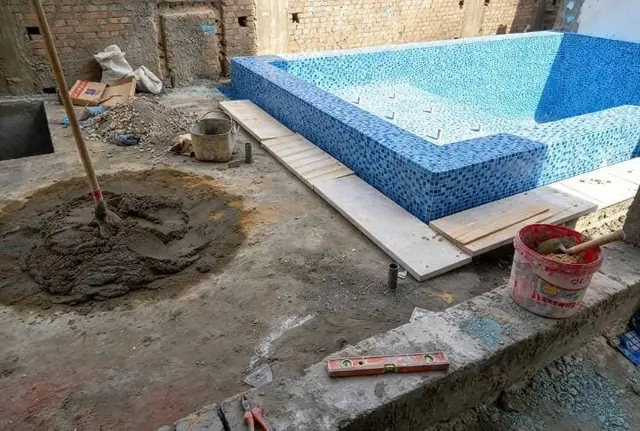 Tiled pool body with surroundings being prepared