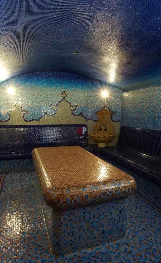 Vaulted hammam in blue mosaic with golden massage slab