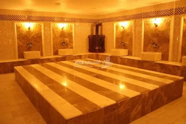 Hammam with striped marble platform and warm light