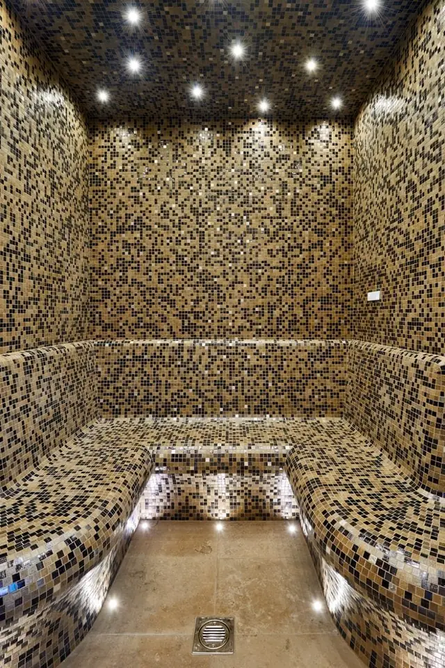 Steam room with tiered benches and illuminated ceiling